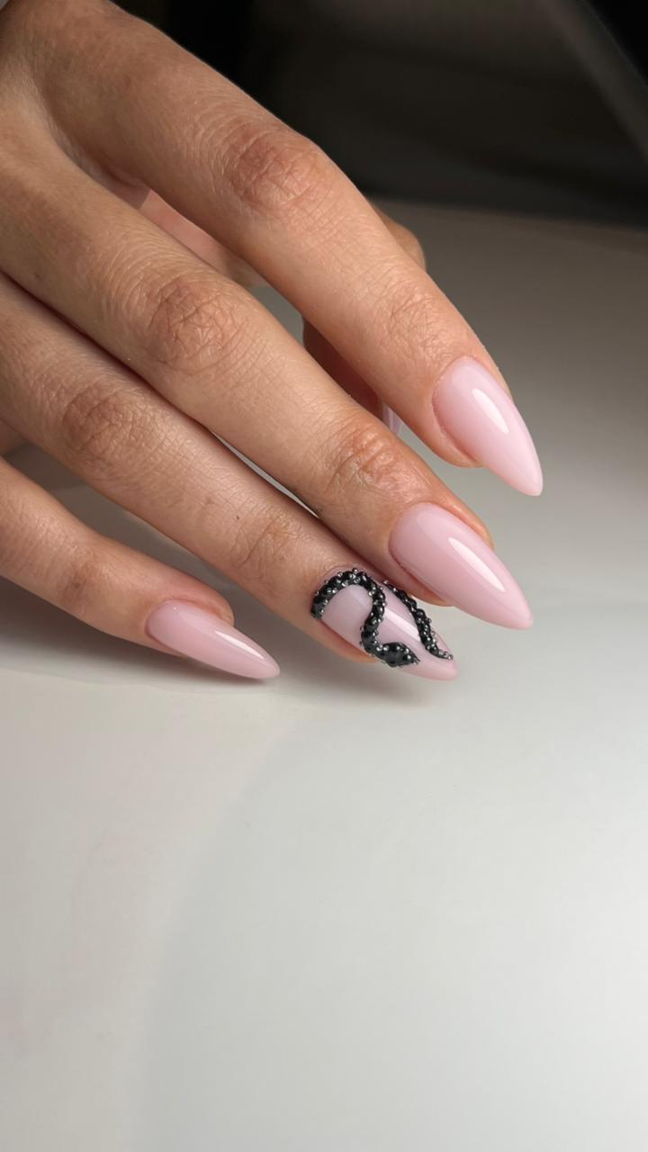 Blush almond nails with a black caviar-bead accent