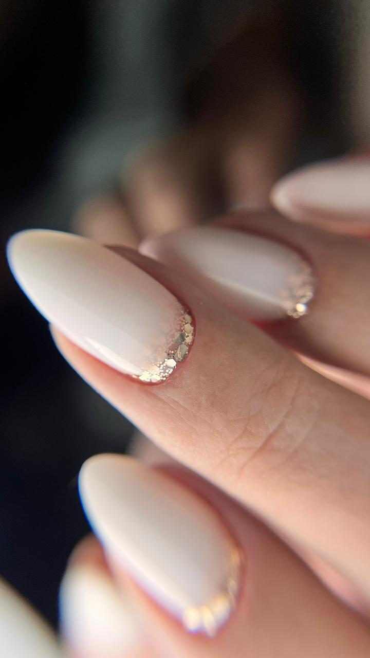 Nude almond nails with gold-foil cuticle accent